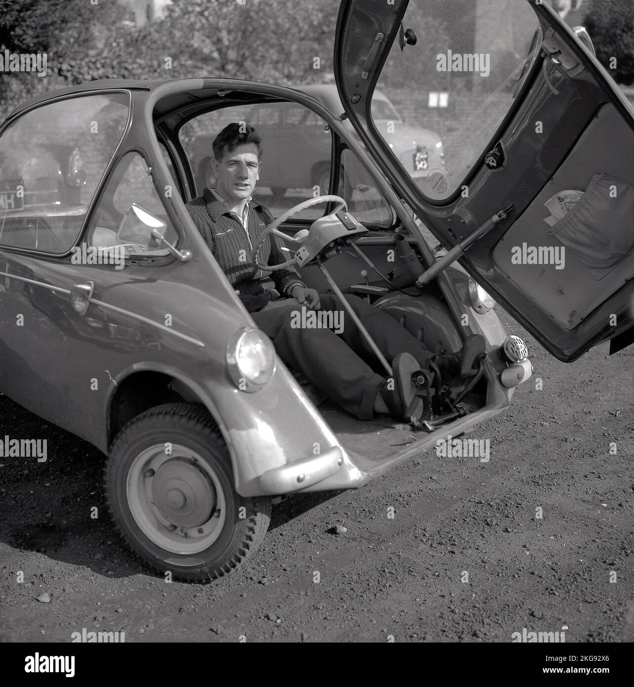 1960s, storico, uomo seduto in una macchina bolla, porta aperta, Inghilterra, Regno Unito. Foto Stock