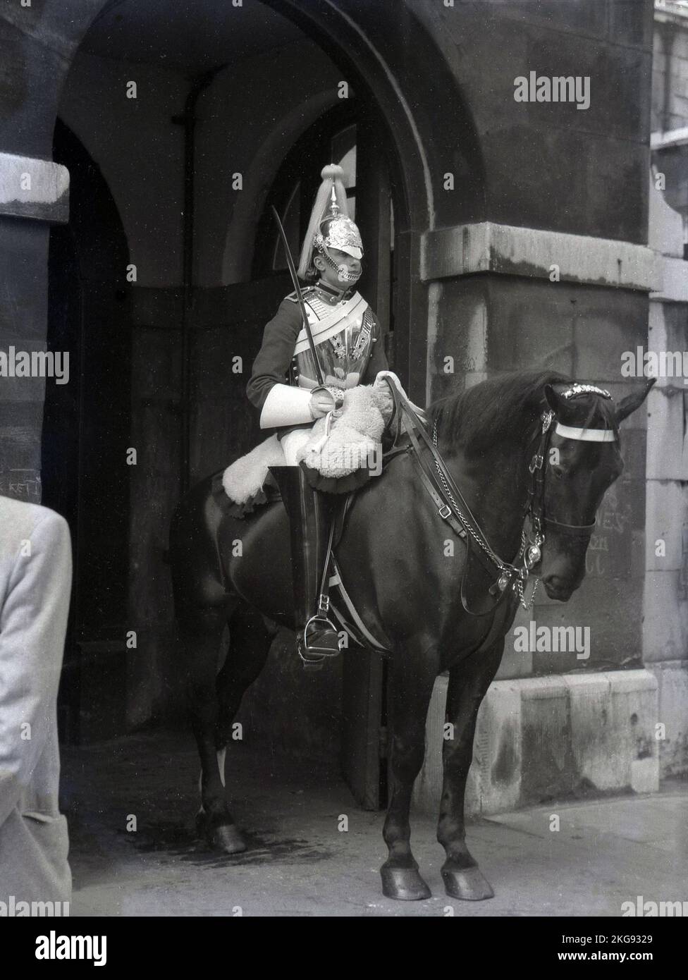 1950s, storico, una guardia di cavalli montata all'ingresso cerimoniale di St James e Buckingham Palace, il quartier generale della Household Cavalry Mounted Regiment, Westminster, Londra, Inghilterra, Regno Unito. Foto Stock