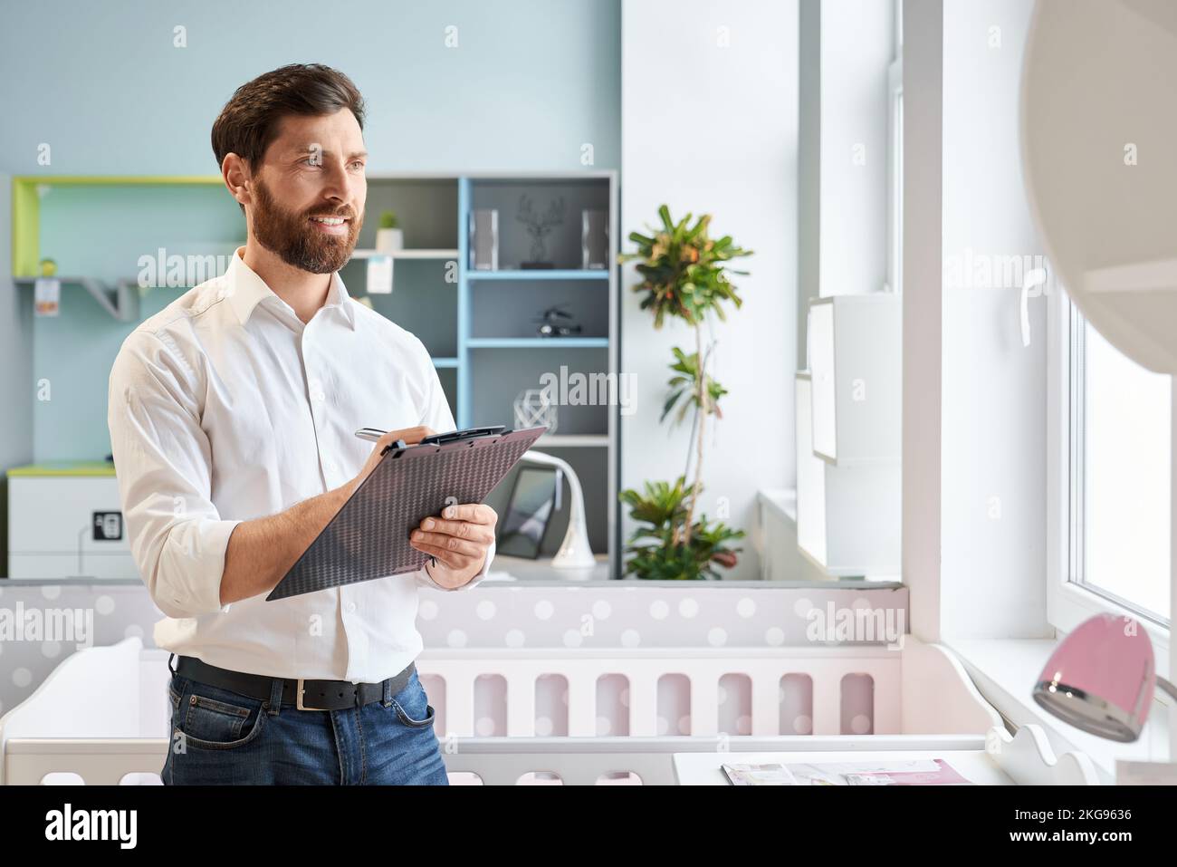 Responsabile vendite di successo con un tablet a clip nel negozio di mobili. Ritratto di sorridente scrittoio al dettaglio, confrontare i prezzi, mentre guardando armadio in centro espositivo. Concetto di luogo di lavoro. Foto Stock