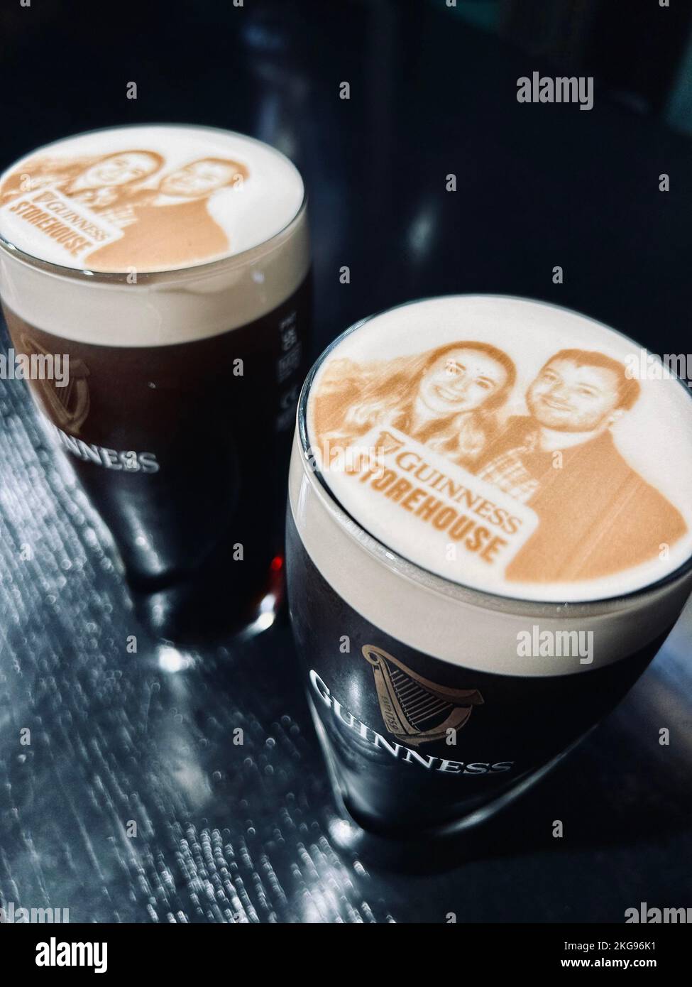 Una pinta di Guinness come una stoutie con l'immagine di una giovane coppia stampata sulla testa Foto Stock