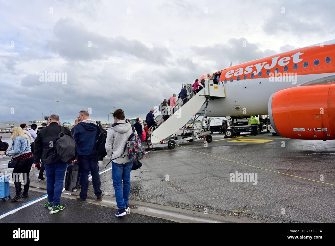 I passeggeri che accodano e salgono a bordo di un aereo/aereo EasyJet Airbus tramite scale Foto Stock