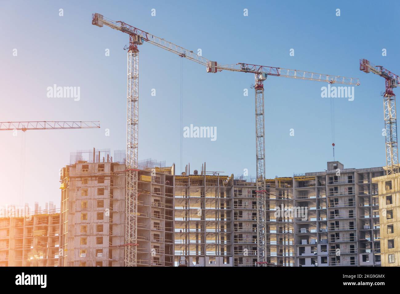 Costruzione di immobili residenziali in cemento e mattoni. Vista su case e gru di alto livello. Foto Stock