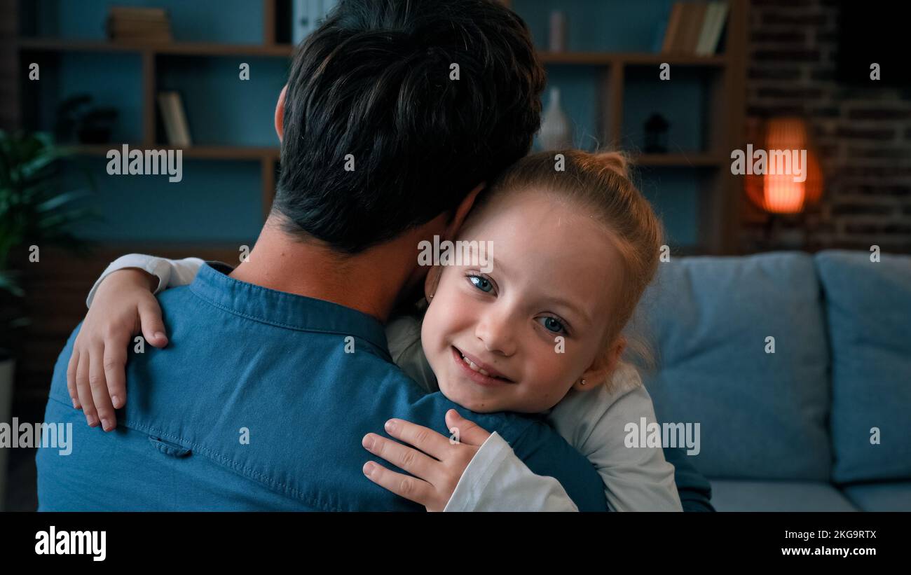 Amorevole figlia carina abbracciare adorabile papà felice giovane famiglia caucasica singolo padre abbracciando bambina a casa il giorno del padre genitori Foto Stock