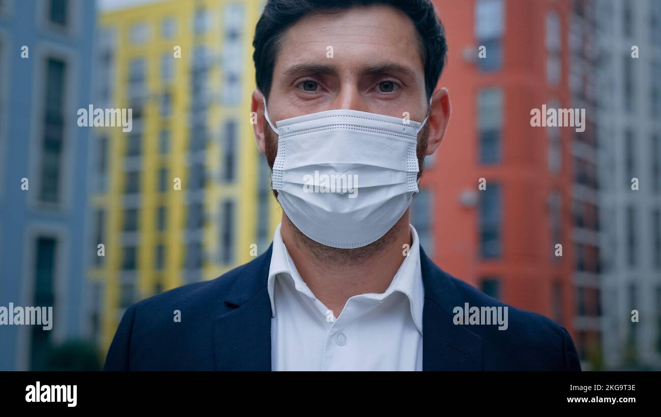 Uomo d'affari adulto malato uomo allergico in maschera protettiva respiratore sicurezza personale a causa di pandemia tempo misure mediche da coronavirus o stagionale Foto Stock