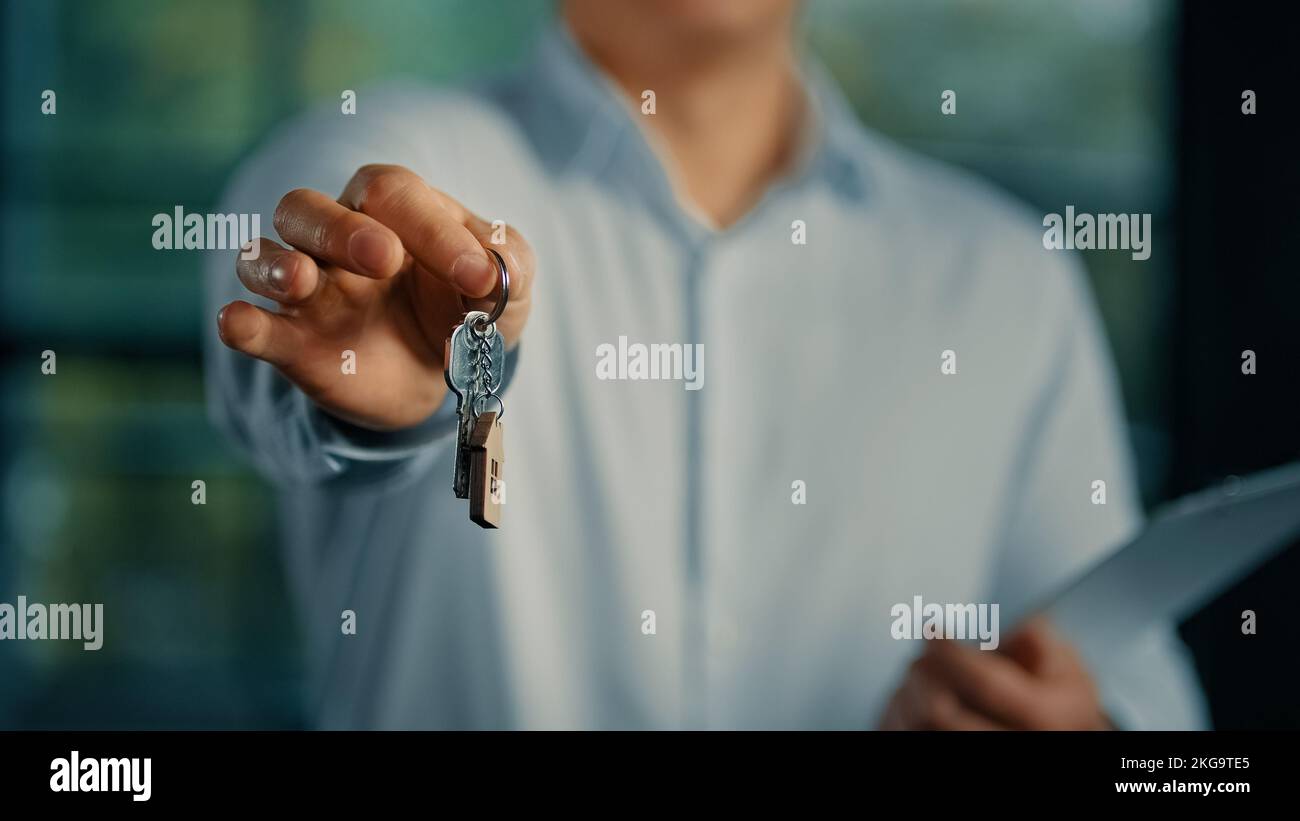 Agente immobiliare venditore banchiere businessman show a macchina fotografica mazzo di chiavi da nuova casa commerciale offerta alloggio ipoteca buon proprietario di casa compratore affitto Foto Stock