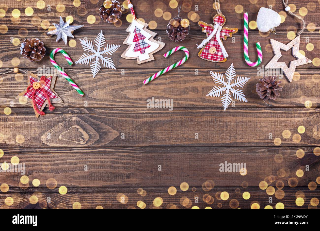 Bella composizione di Natale su sfondo di legno con coni di conifere di Natale, decorazione di festa, bastone di caramello. Vista dall'alto, spazio di copia. Foto Stock