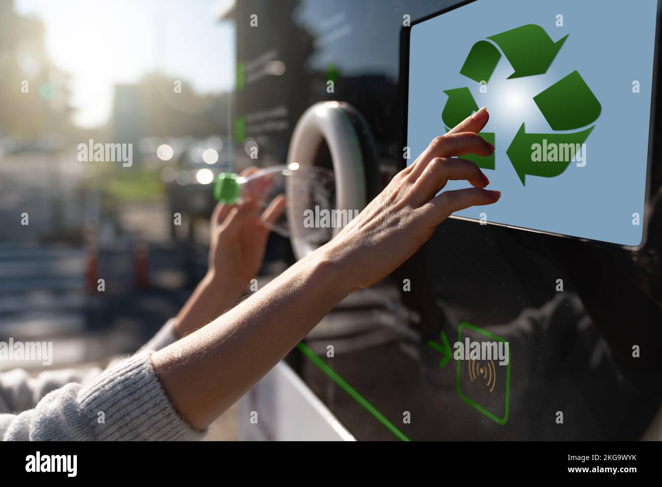 Donna utilizza una macchina self-service per ricevere bottiglie di plastica usate e lattine su una strada cittadina Foto Stock