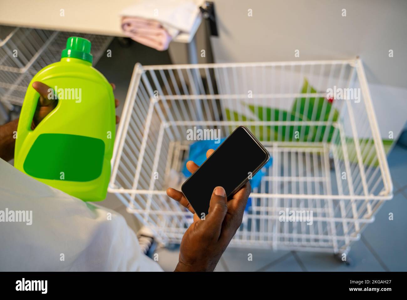 Maschio con un cellulare nelle mani di una lavanderia self-service Foto Stock