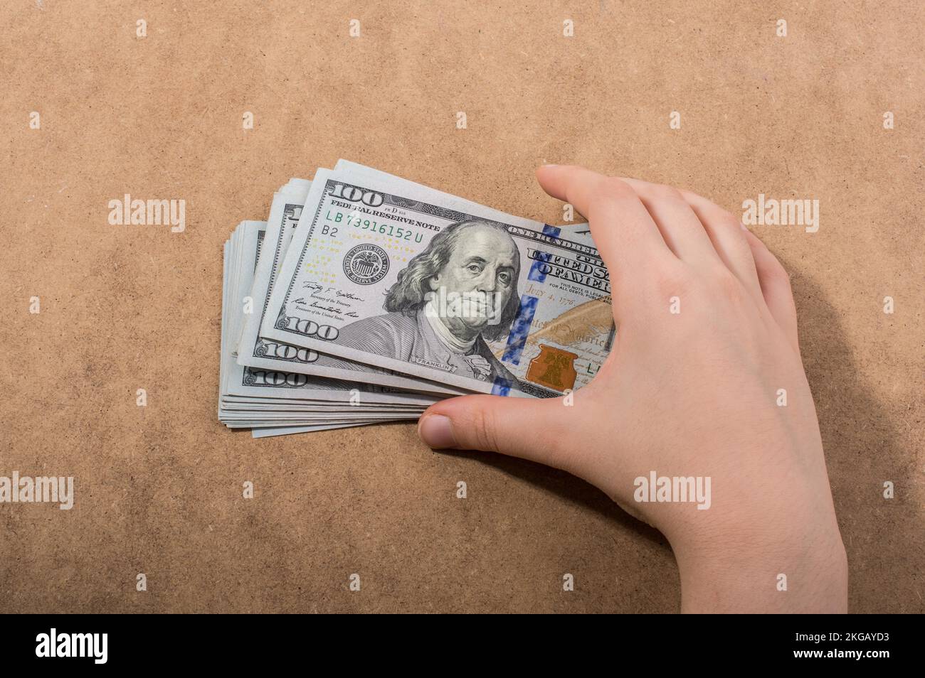 Mano che tiene le banconote del dollaro americano isolate su fondo di legno Foto Stock