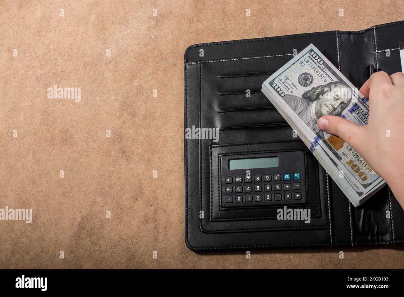 Mano azienda dollaro americano banconote accanto a una calcolatrice Foto Stock