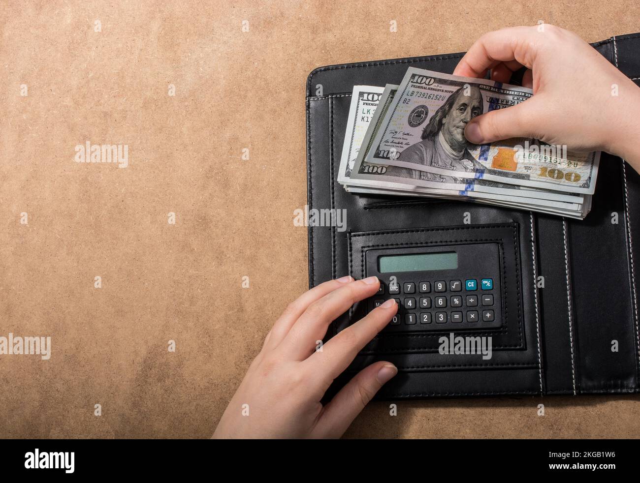 Mano azienda dollaro americano banconote accanto a una calcolatrice Foto Stock