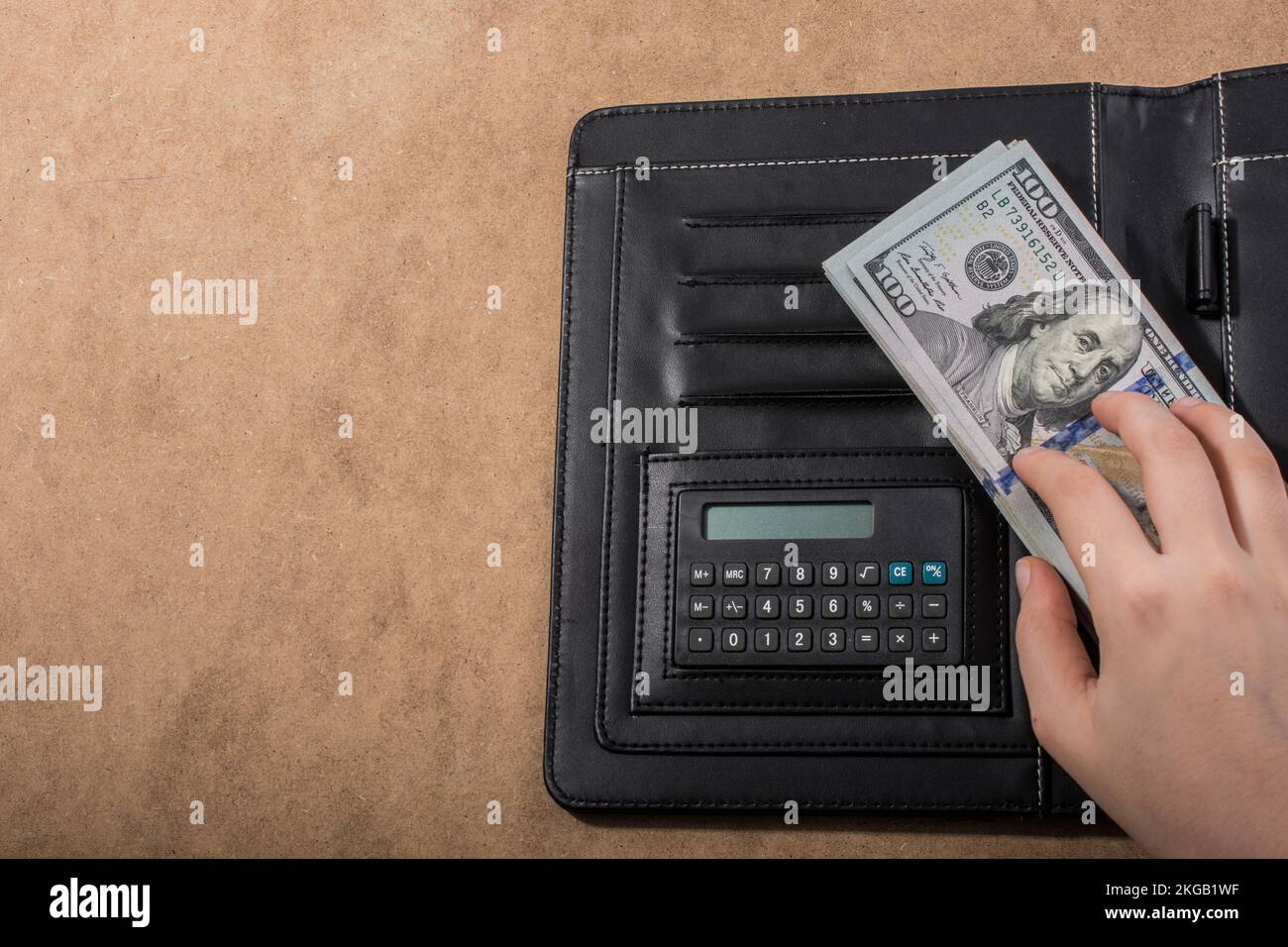 Mano azienda dollaro americano banconote accanto a una calcolatrice Foto Stock
