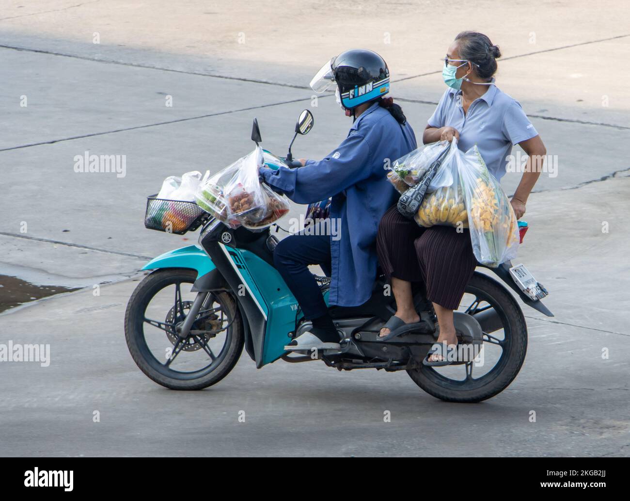 SAMUT PRAKAN, THAILANDIA, 23 2022 SETTEMBRE, la coppia con molti sacchetti di plastica completi cavalca su moto Foto Stock