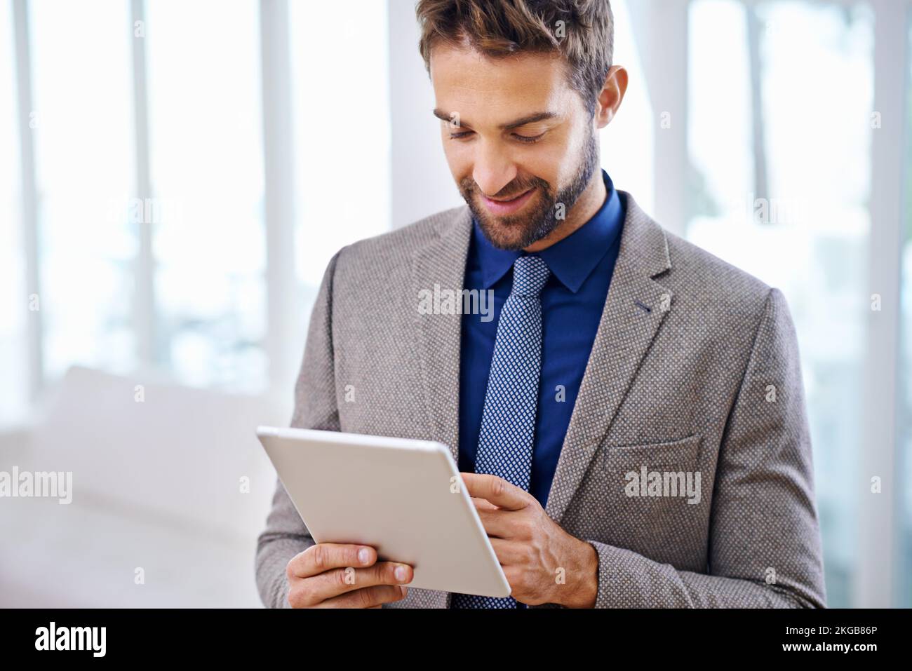 Estremamente facile da usare. Uomo con un abito contemporaneo che tiene un tablet. Foto Stock