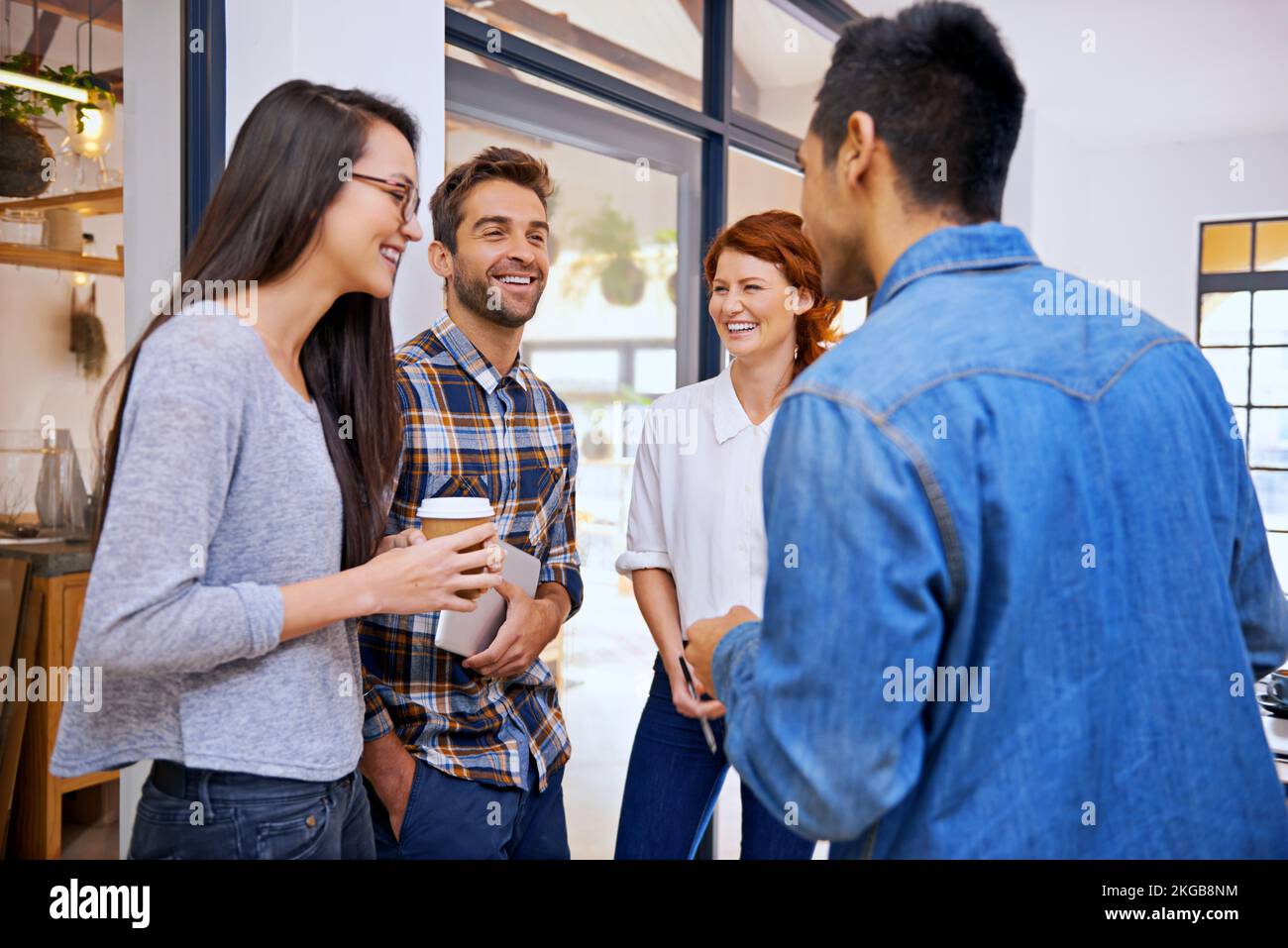Godendo della loro occupazione creativa. quattro giovani designer che chiacchierano in ufficio. Foto Stock