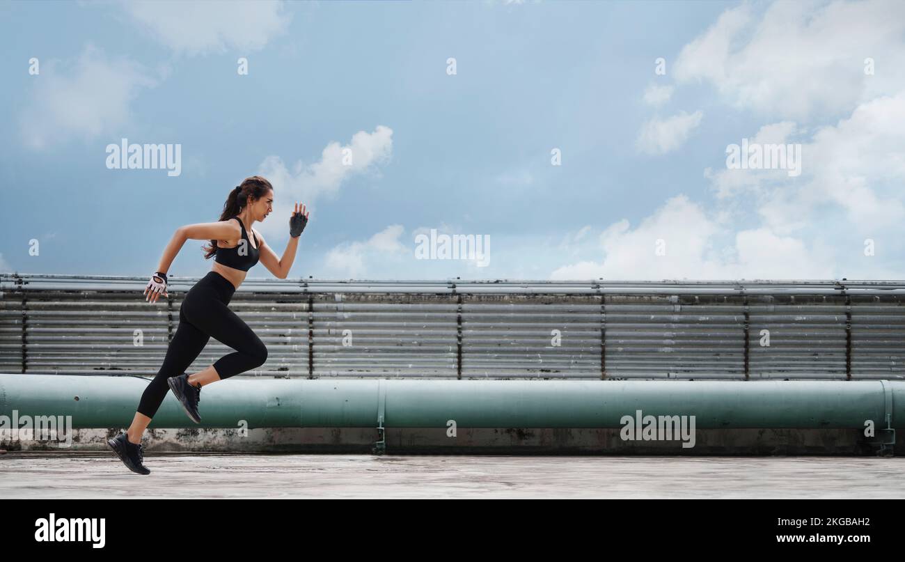Atleta donna che fa esercizio di corsa e affondo sul tetto. Foto Stock