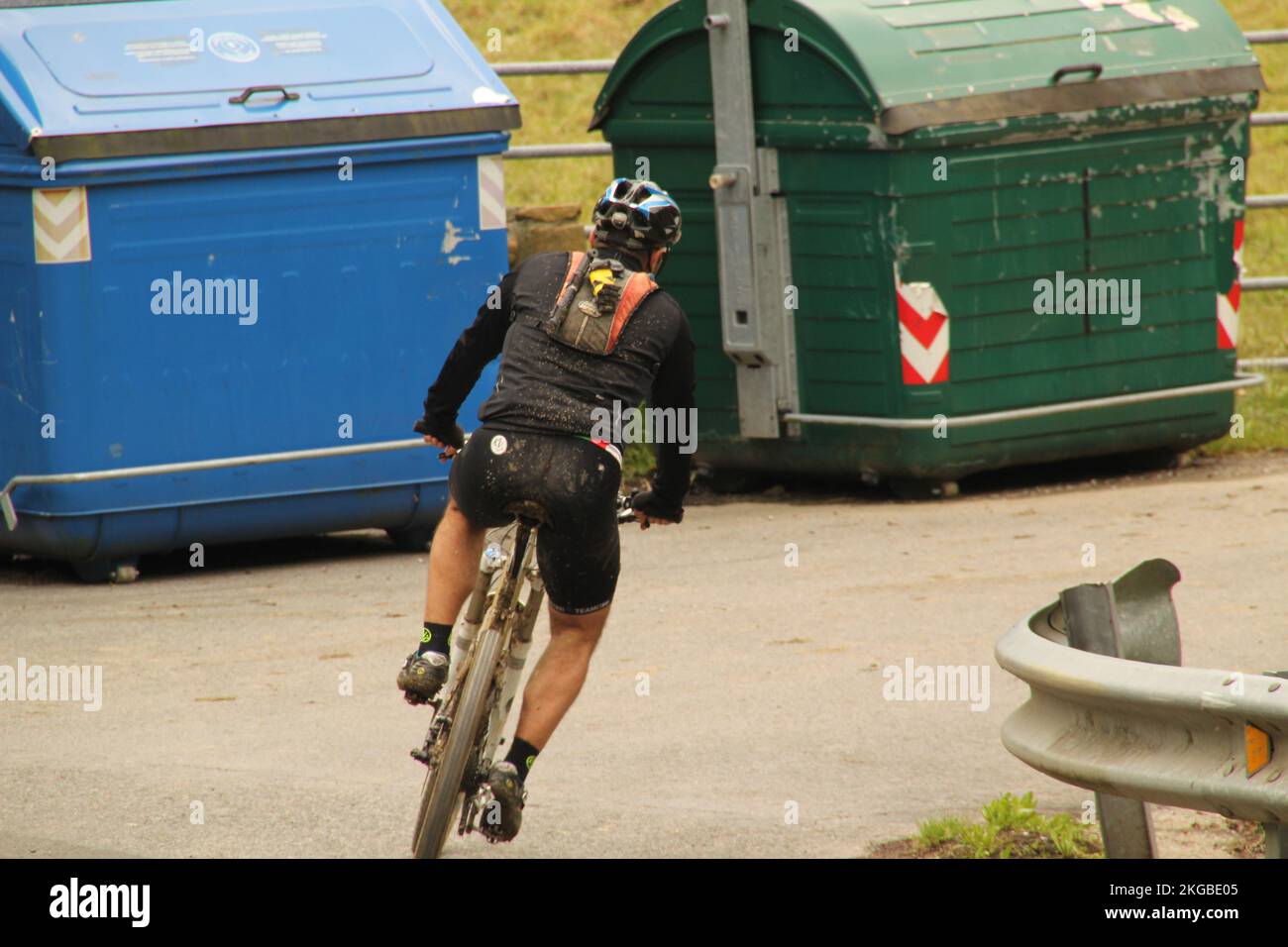 Un uomo con un casco in bicicletta per le strade di Bilbao. Spagna Foto Stock