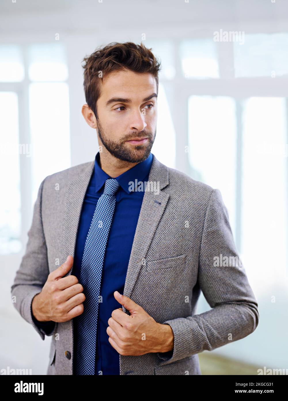 Elegante e professionale. Uomo con un abito contemporaneo che guarda lontano. Foto Stock