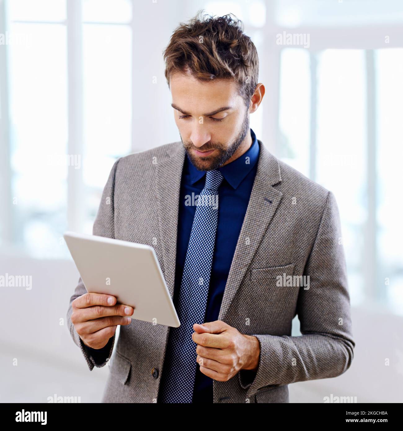 Focussed sulla tecnologia attuale. Uomo con un abito contemporaneo che tiene un tablet. Foto Stock