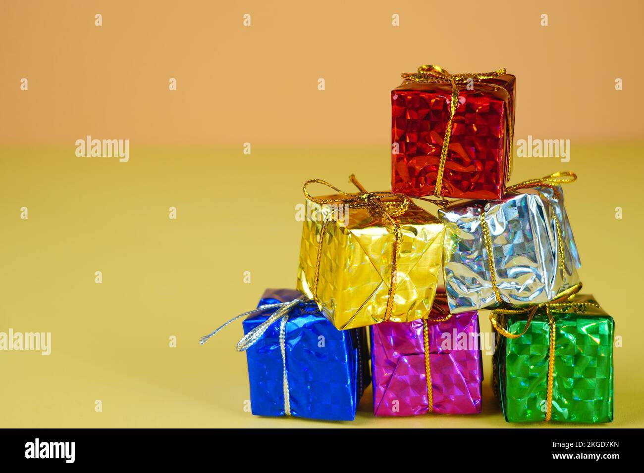 Pila di regali colorati metallici con corde d'oro isolate Foto Stock