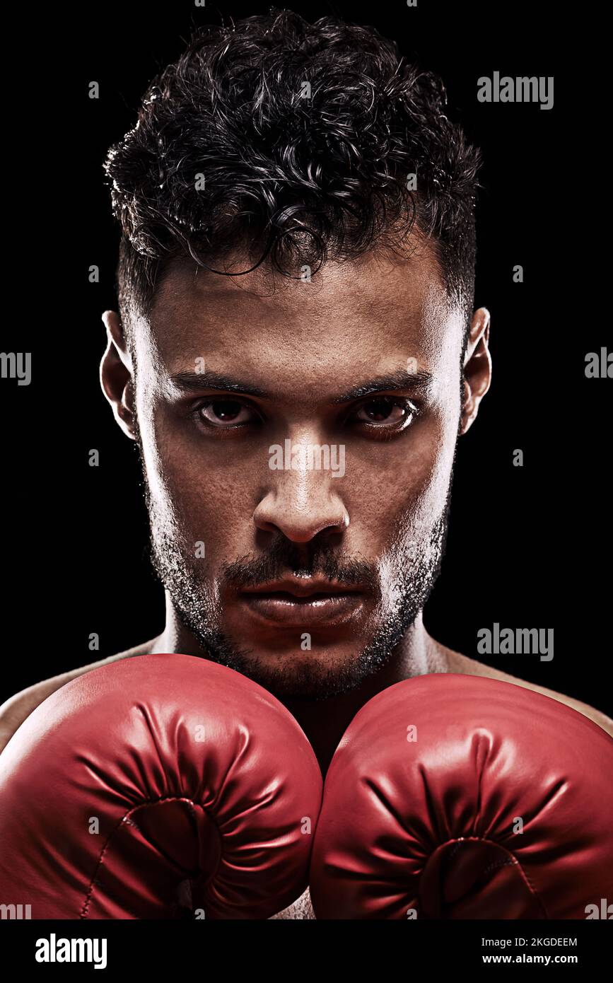 Conosci te stesso e vincerai tutte le battaglie. Ritratto di un giovane uomo che indossa guanti da boxe su sfondo nero. Foto Stock