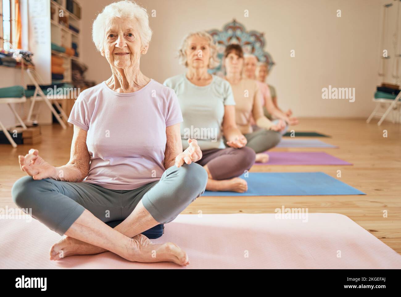 Yoga, esercizio fisico e donna anziana in lotus per la meditazione, la consapevolezza e zen allenamento per la salute e il benessere in pensione. Gruppo di anziani Foto Stock
