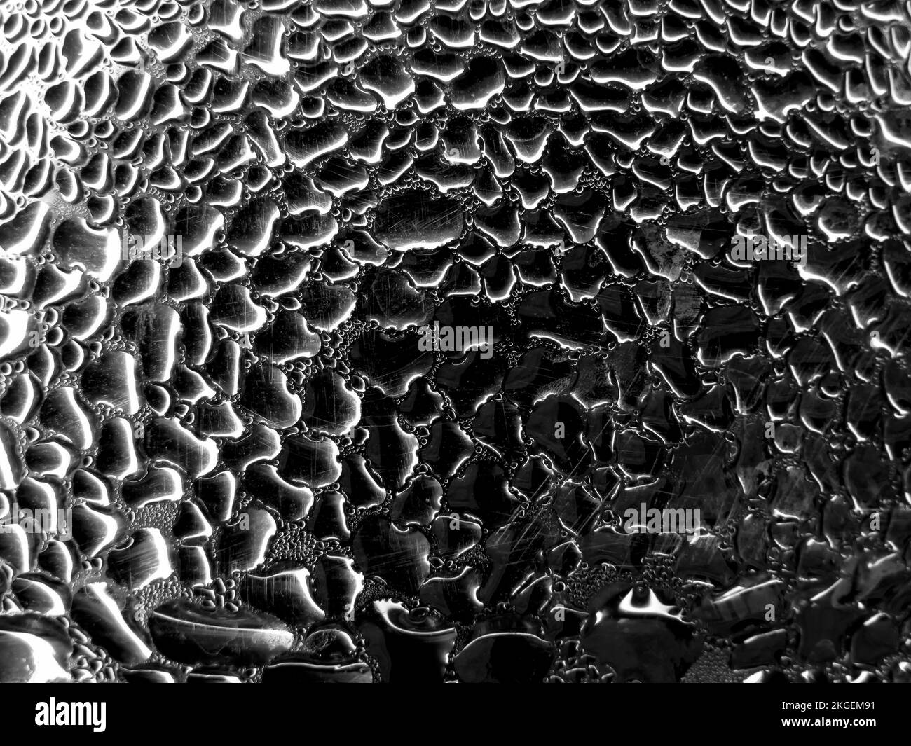 Vetro con gocce di pioggia su sfondo di tonalità scure. Struttura bagnata astratta con bolle sulla superficie del vetro della finestra. Gocce d'acqua pura realistica conde Foto Stock
