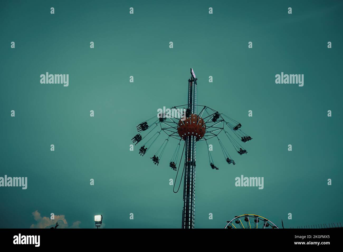 Sedia a torre rotante che si muove al Fun fair di notte. Foto Stock