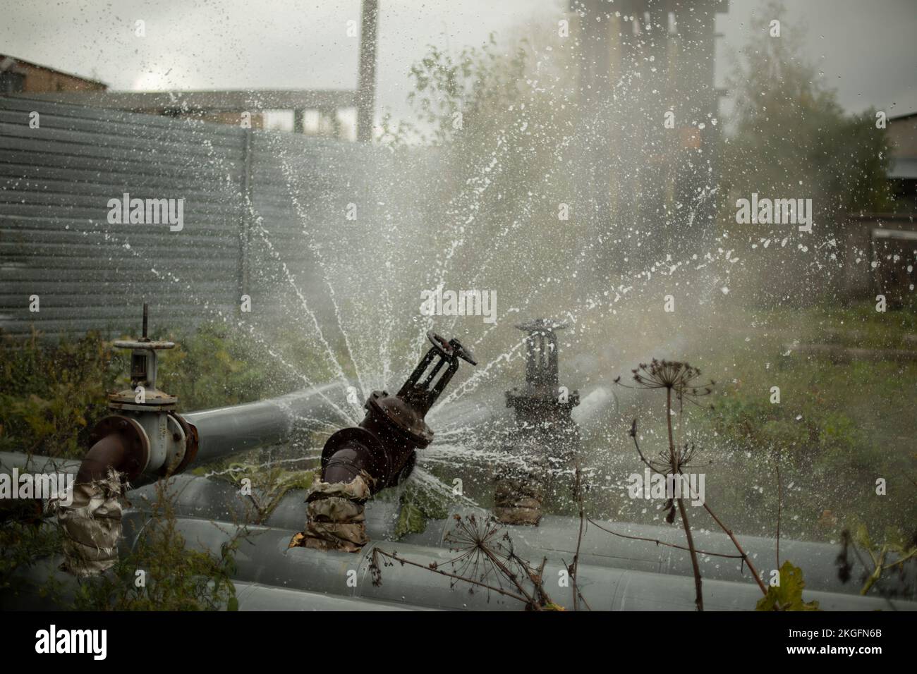 Fuoriuscita di acqua dal tubo rotto. Innovazione della pipeline. Incidente nella stazione di caldaia. Flusso di acqua. Foto Stock
