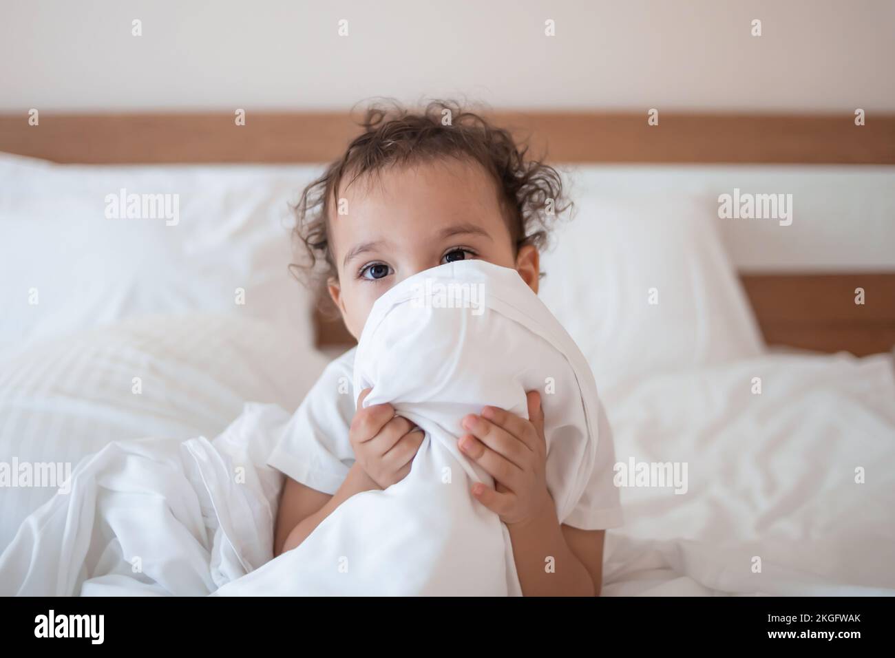 Il volto di chiusura del bambino con coperta gioca con i genitori sul letto Foto Stock