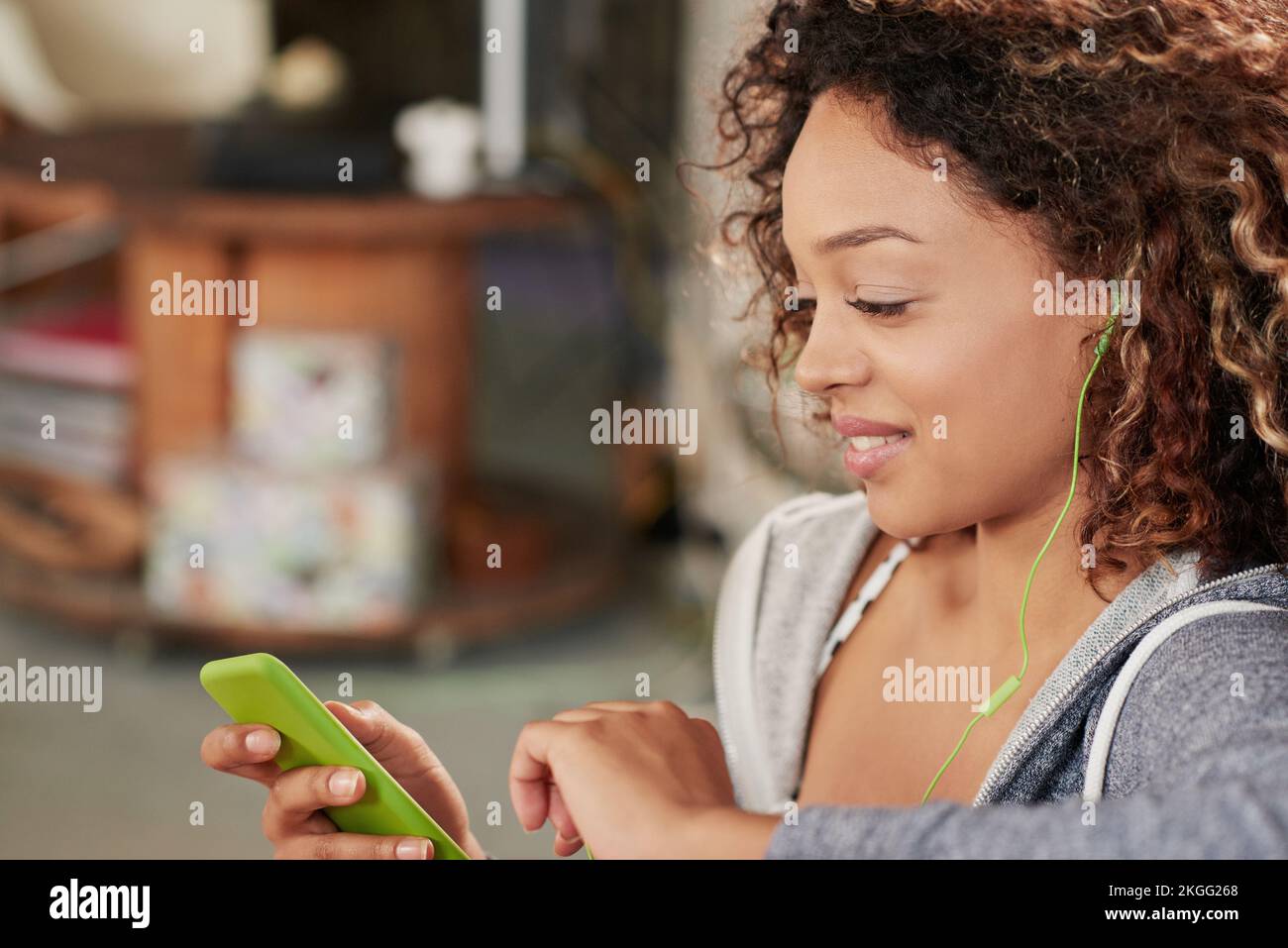 Donna nera, telefono e ascolto di musica per rilassarsi con lo smartphone per lo streaming, podcast e la comunicazione con il wifi domestico. Felice femmina africana su Foto Stock