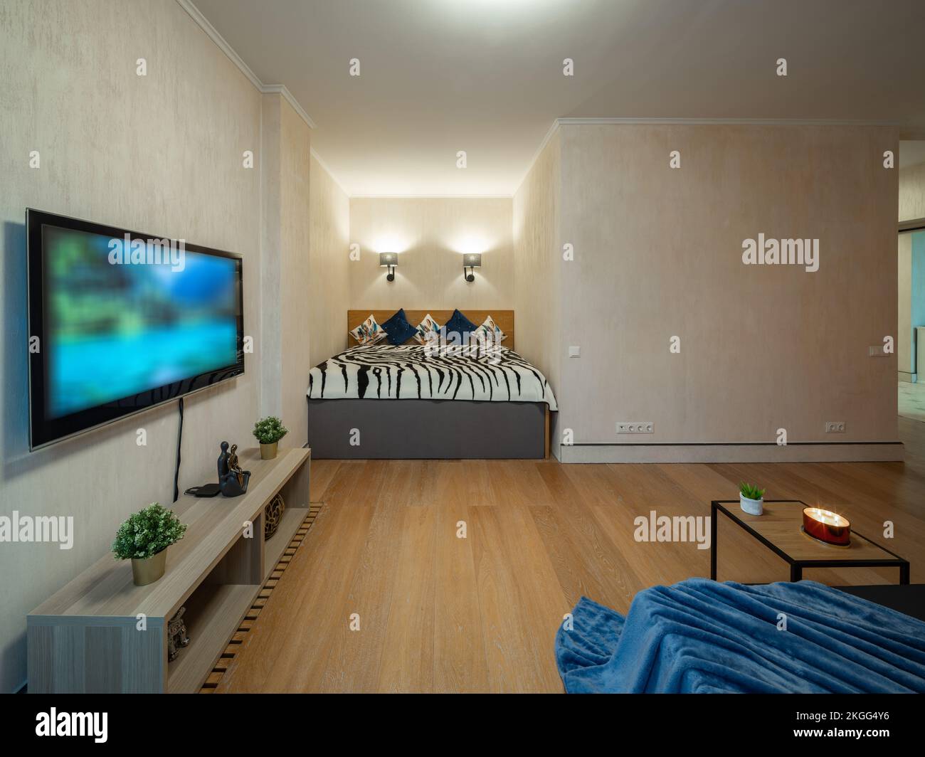 Interni moderni della camera da letto. TV a parete. Letto comodo. Foto Stock