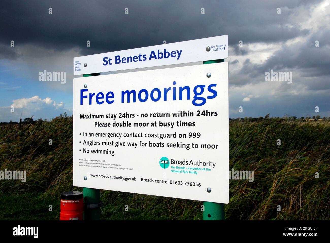 Firma per gli ormeggi gratuiti sul fiume Bure presso l'Abbazia di St Bennets, Norfolk, Inghilterra, con nuvole grigie scure sovrastanti Foto Stock