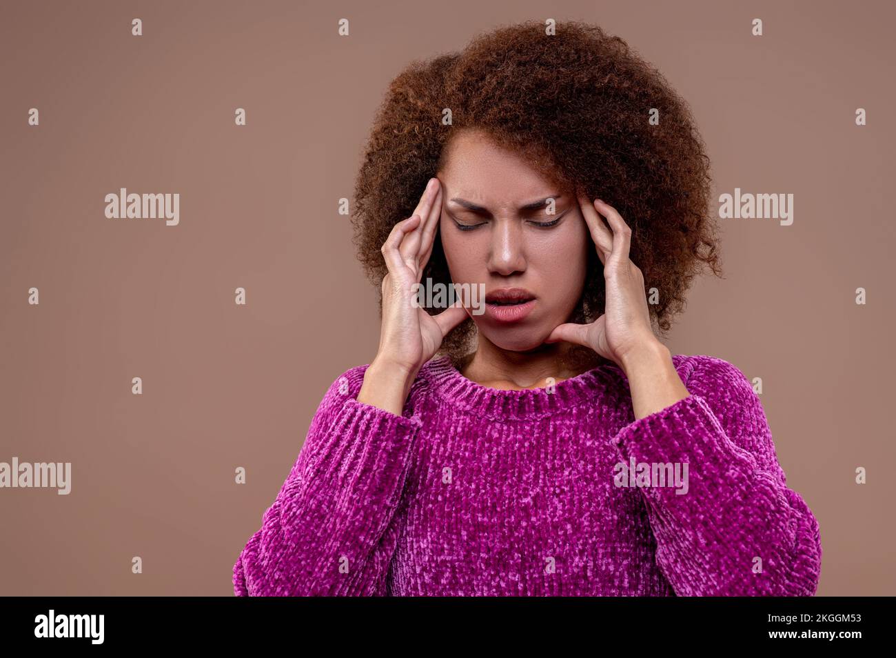 Giovane donna dai capelli scuri che soffre di mal di testa Foto Stock