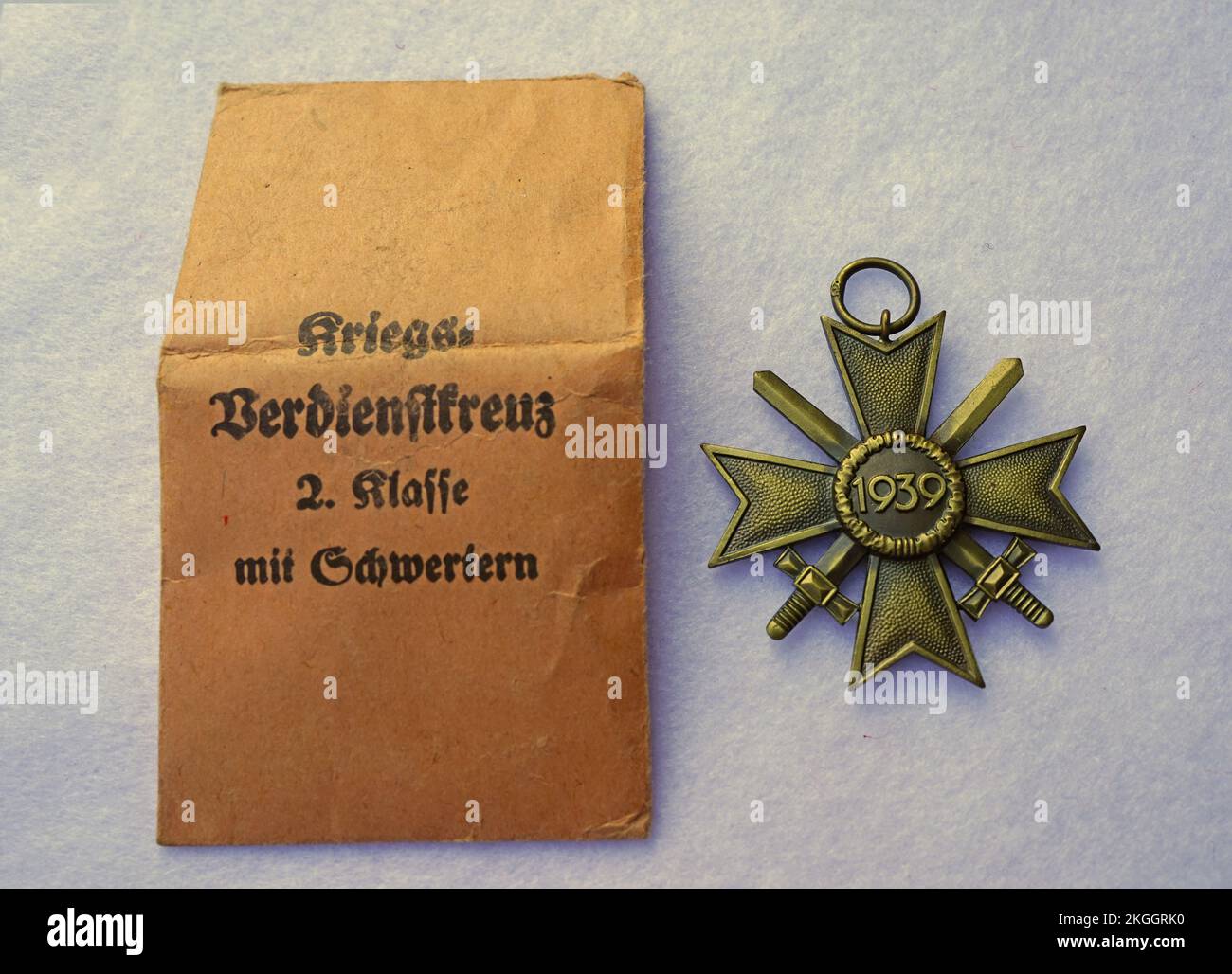 Un'antica medaglia di guerra tedesca della seconda guerra mondiale con il corrispondente sacchetto di carta marrone. Guerra Merit Cross Foto Stock