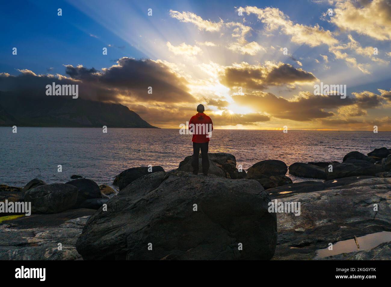 Escursionista in piedi sulla spiaggia di Tungeneset al tramonto, Isola di Senja, Norvegia settentrionale Foto Stock