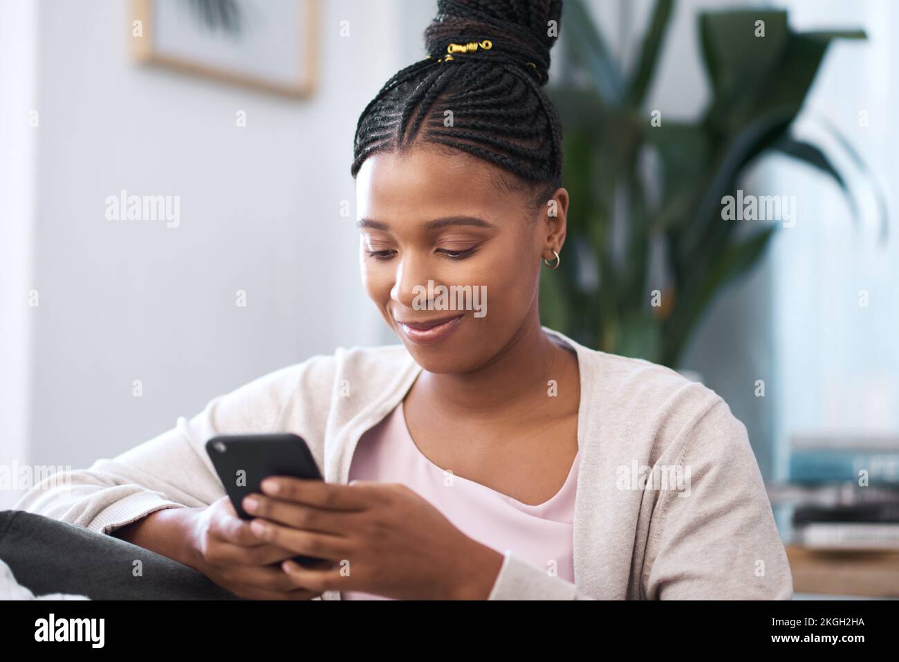 Donna nera, smartphone per social media e divano del soggiorno, relax, digitazione e connessione online, notifiche di lettura e sito internet delle cose. Giovane africano Foto Stock
