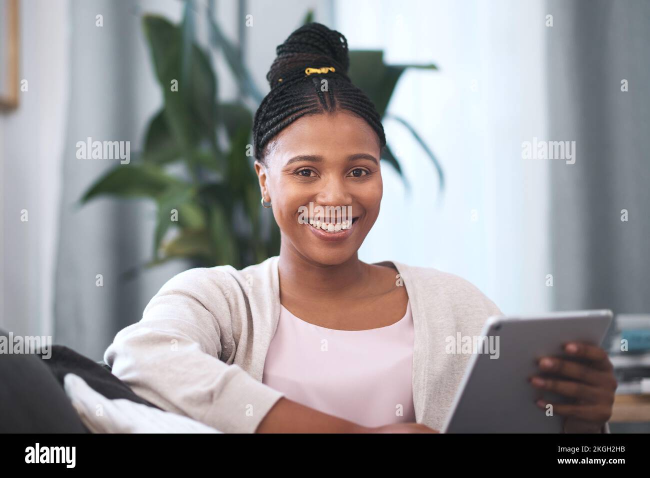 Donna nera, tablet e ritratto sorriso sul divano per i social media, la comunicazione o l'intrattenimento a casa. Felice afro americano femmina sorridente e. Foto Stock