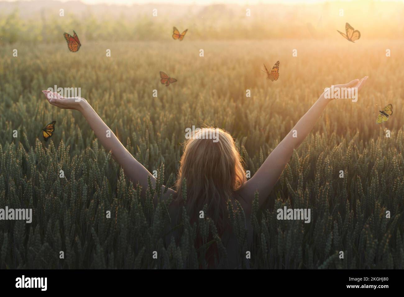 incontro surreale tra una donna e farfalle libere che volano in mezzo alla natura Foto Stock