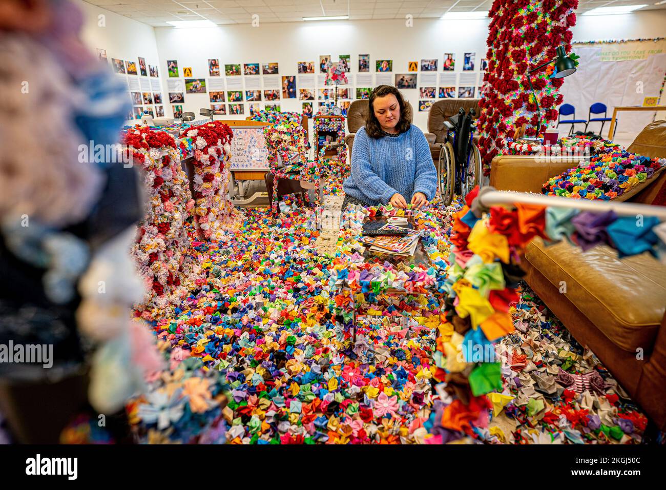 Un'installazione di fiori creato da Carer Carina Andrews (nella foto) per celebrare Carers Rights Day il 24 novembre, presso il centro commerciale Galleries di Broadmead, Bristol. Il pezzo utilizza 40.138 fiori di carta, ognuno dei quali rappresenta un accompagnatore non retribuito nella zona di Bristol, con i fiori realizzati da accompagnatori e volontari nel corso del 2022 e copre un mock up del salotto del genitore di Carina. Data immagine: Mercoledì 23 novembre 2022. Foto Stock