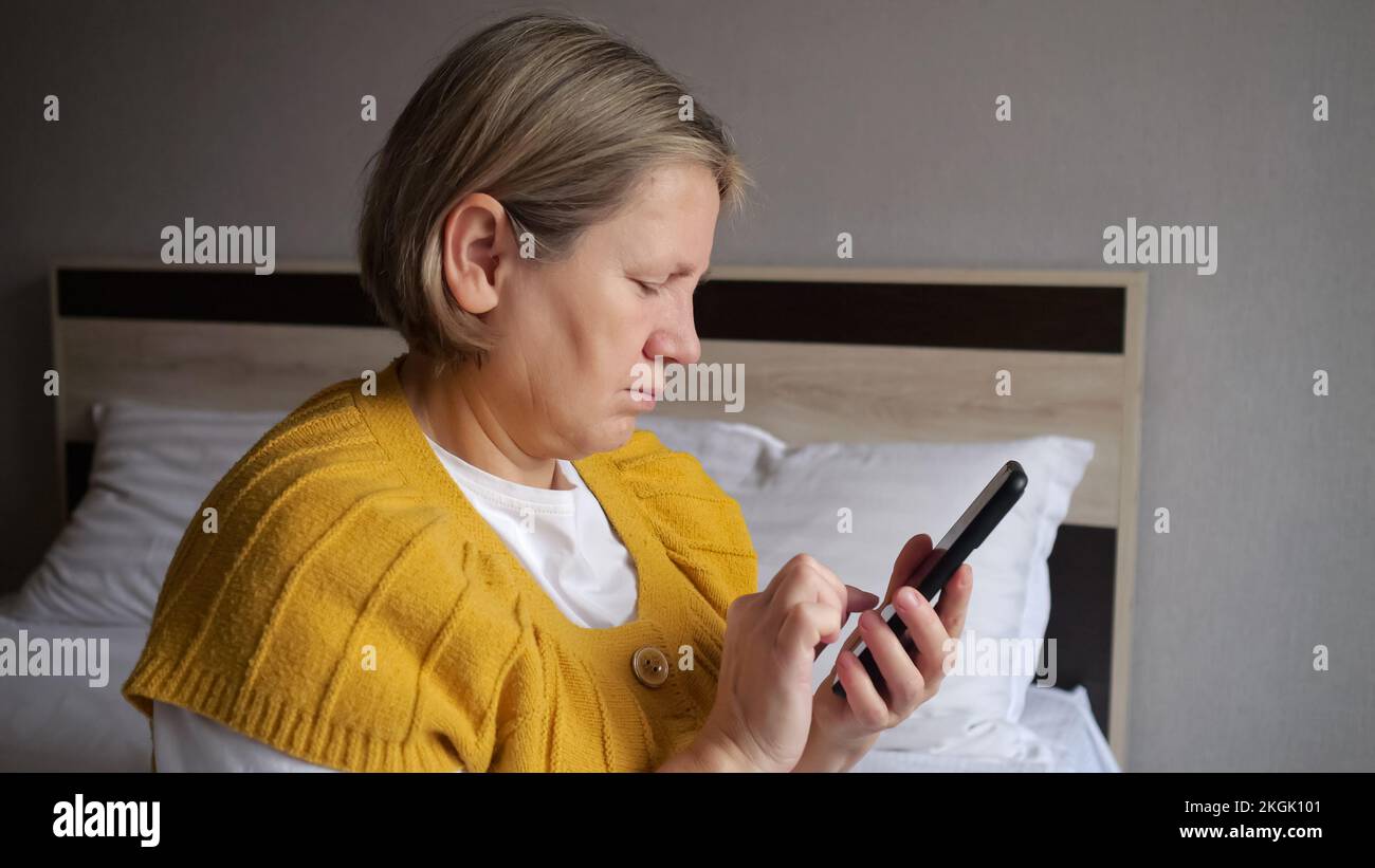 Donna matura solitaria gestisce messaggi di scrittura depressione Foto Stock