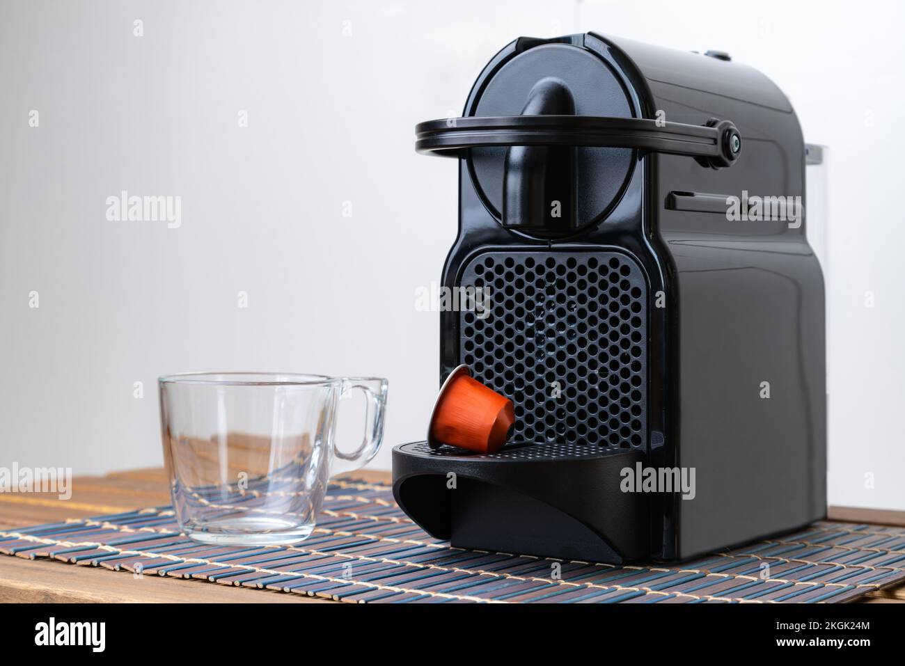 Una vera e propria vita di una capsula e di una tazza di caffè rinfrescanti accanto alla macchina per il caffè all'interno della casa. Nessuno Foto Stock