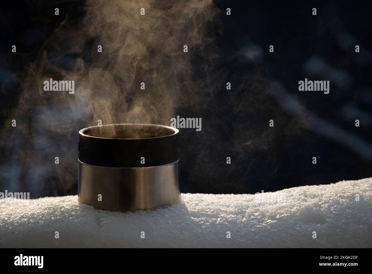 Primo piano della tazza thermos con una bevanda calda a vapore all'esterno sulla neve. Nessuno Foto Stock