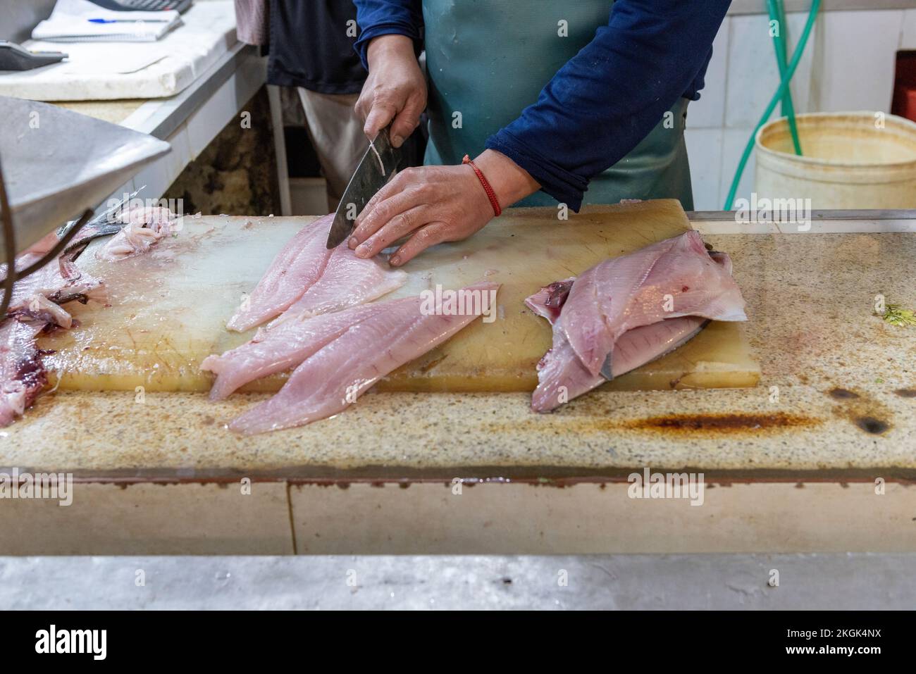 Venditore che prepara pesce al mercato centrale (Mercado Central) a Santiago del Cile Foto Stock