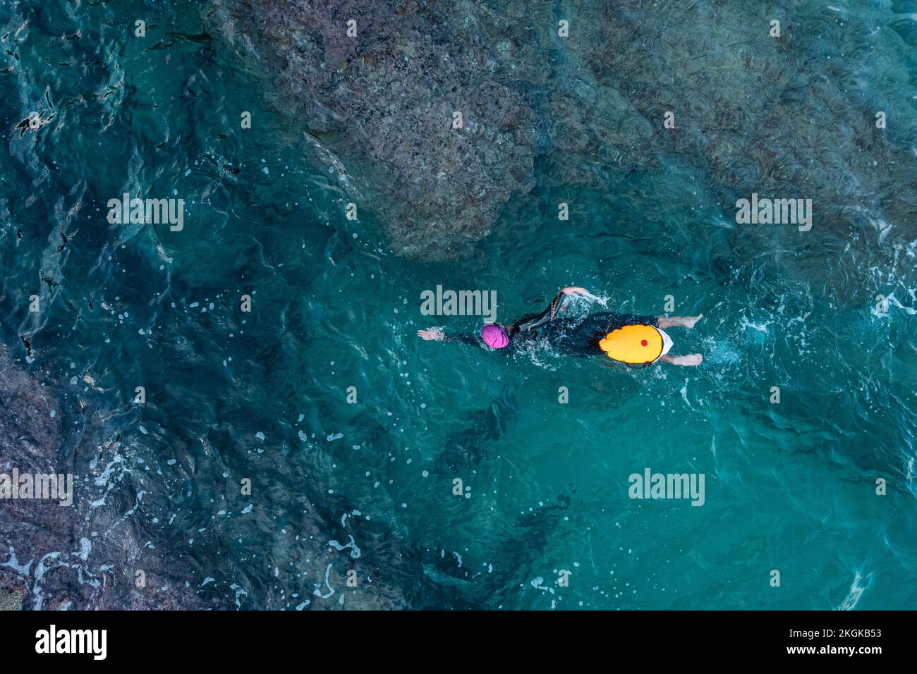 Vista dall'alto dal drone di un nuotatore in acqua aperta con muta e boa Foto Stock