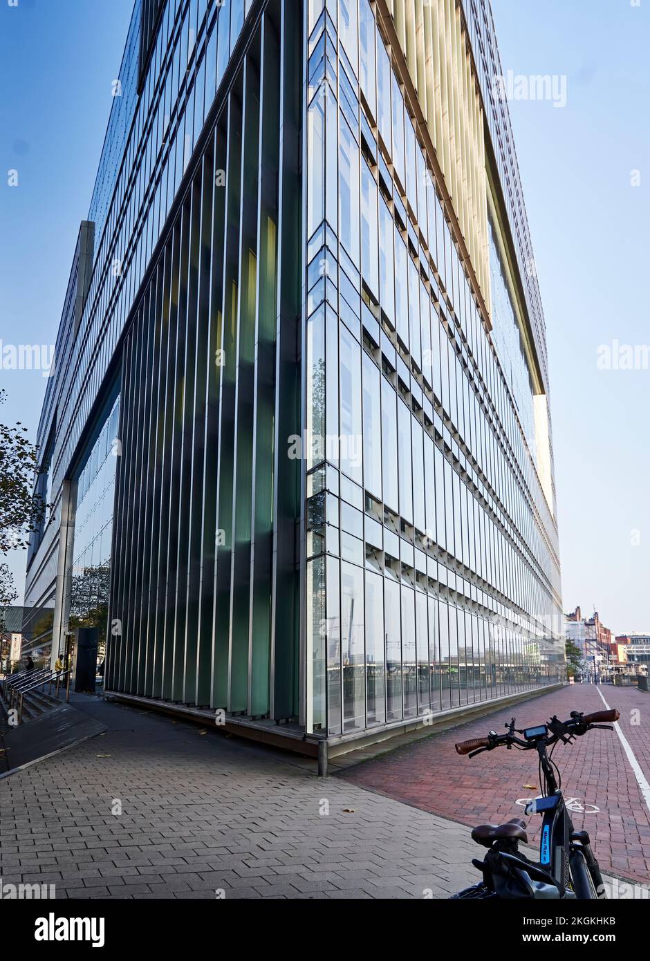 Amburgo, Germania, 11 novembre 2022: Bicicletta di fronte alla facciata in vetro ad angolo acuto dell'edificio degli uffici nel centro della città anseatica di H. Foto Stock