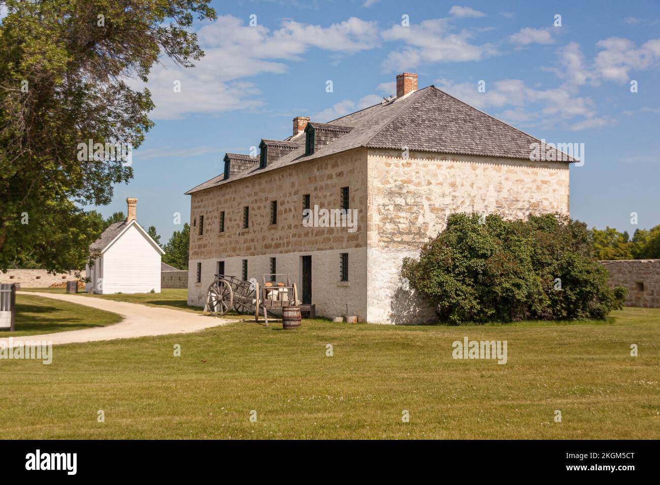 L'edificio principale del sito storico nazionale di Lower Fort Garry con un carretto rosso sul fiume di fronte ad esso Foto Stock