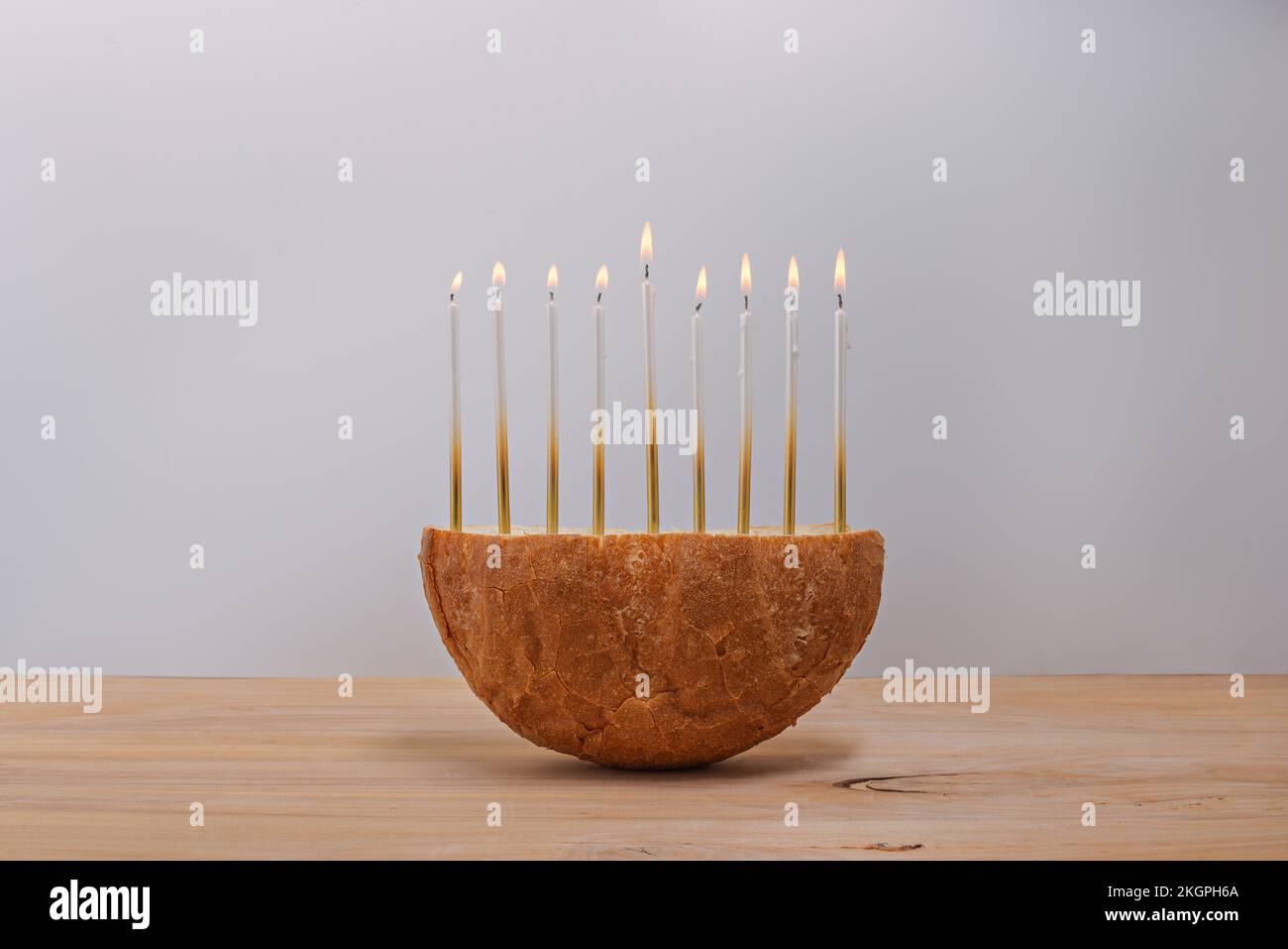 Pane creativo Menorah Hanukkah su un tavolo di legno. Foto Stock