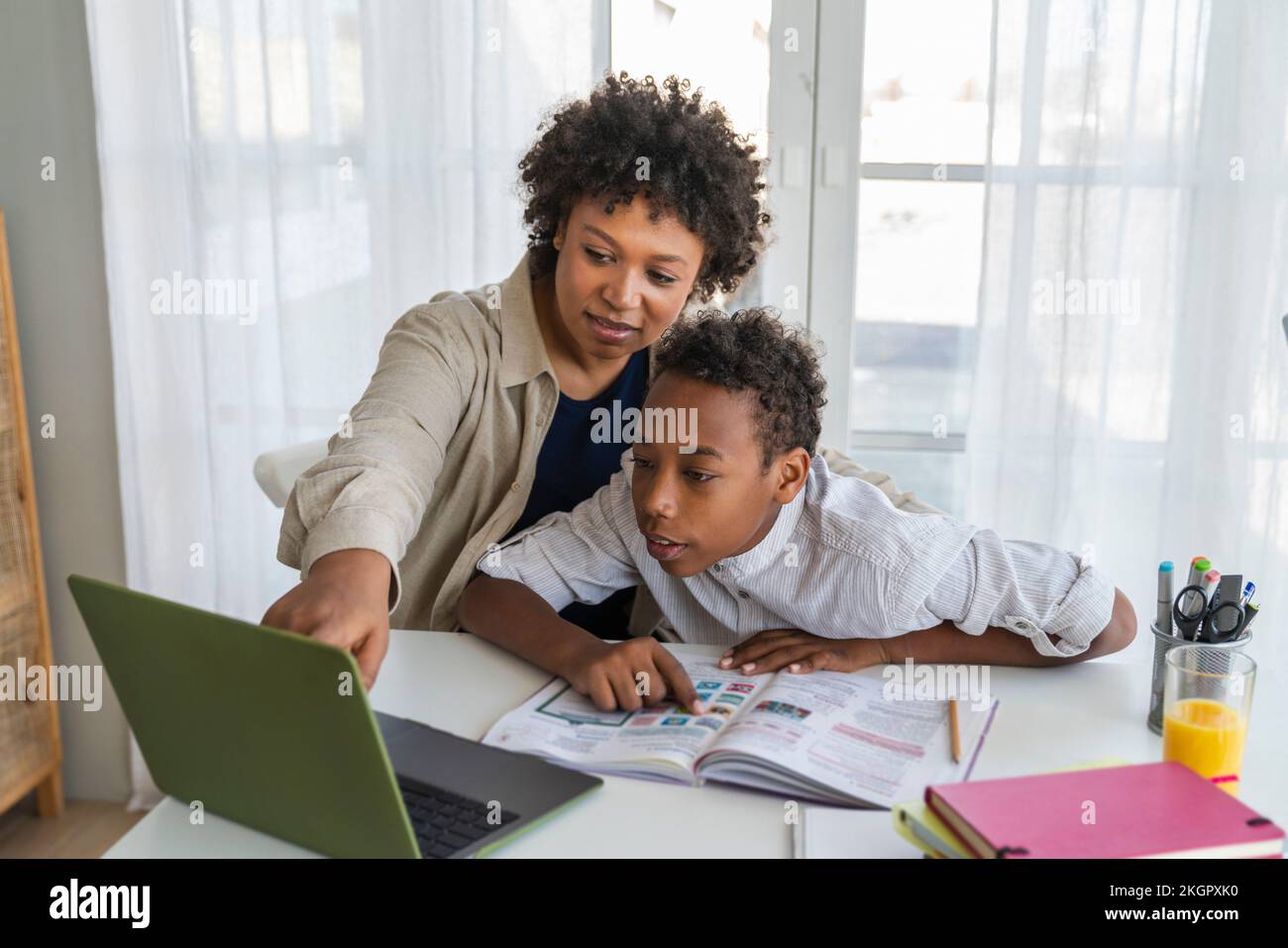 Madre e ragazzo che usano il notebook studiano a casa Foto Stock