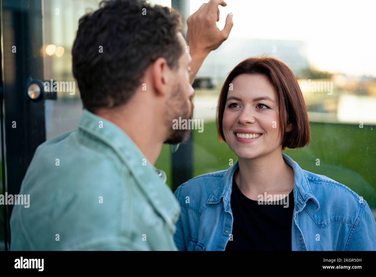 Donna felice con i capelli corti che guardano l'uomo Foto Stock